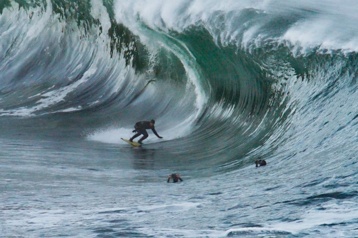 surfer ollie o'flaherty dropping in to a big wave at riley's in ireland