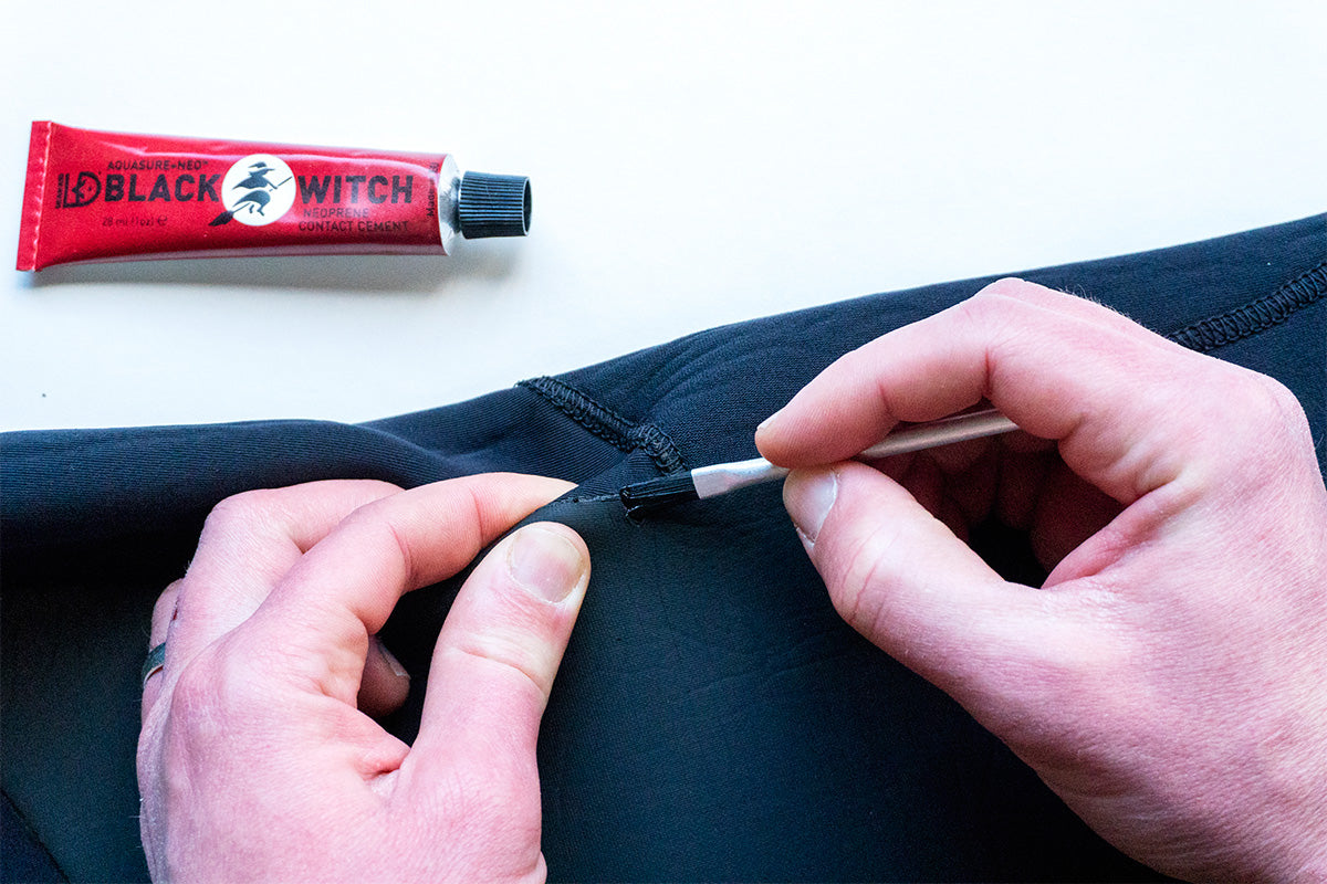 repairing a nick in a wetsuit using black witch neoprene adhesive