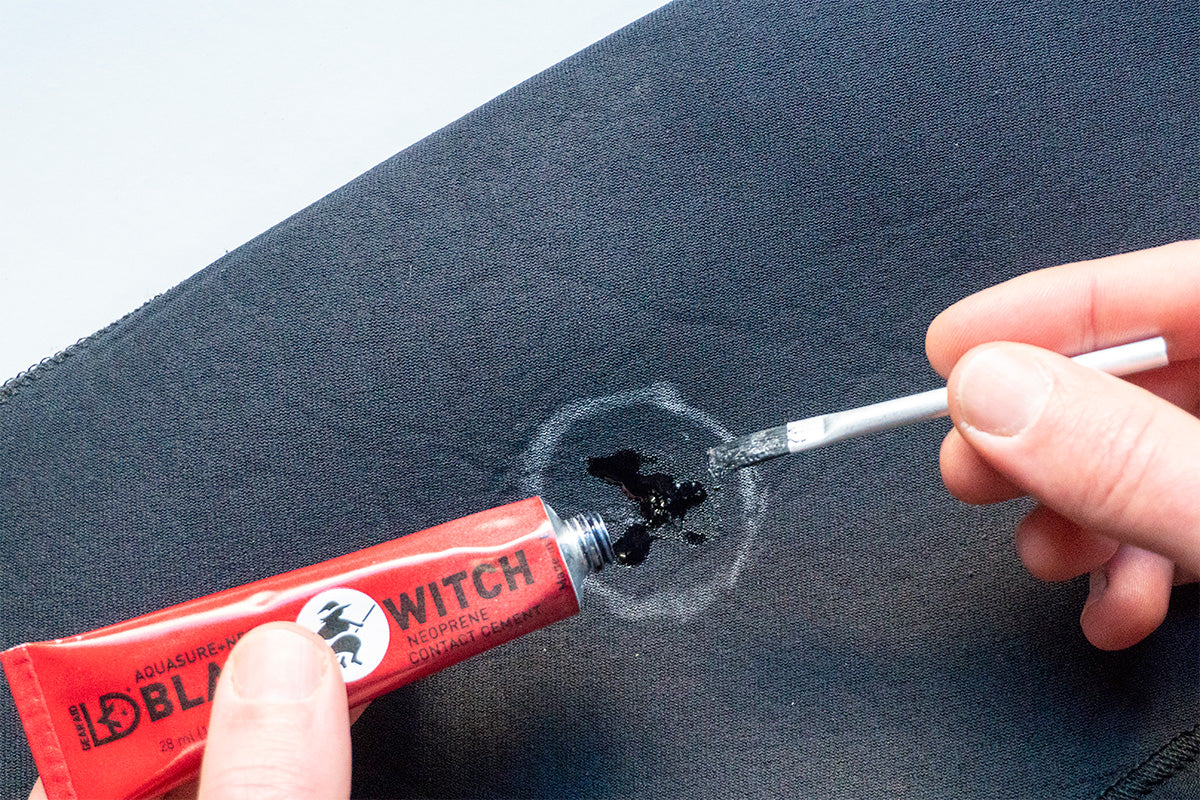 gluing a repair patch onto a wetsuit