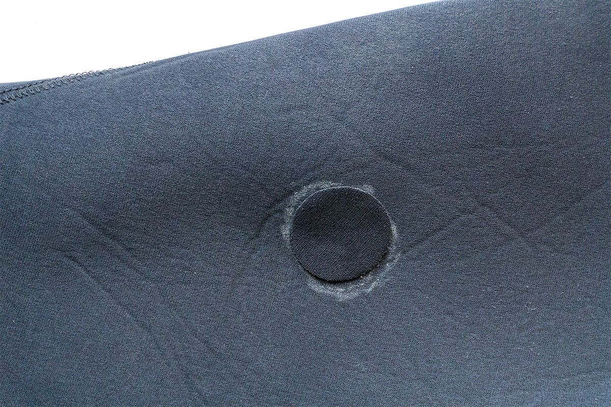 using a patch to repair a small hole in a wetsuit