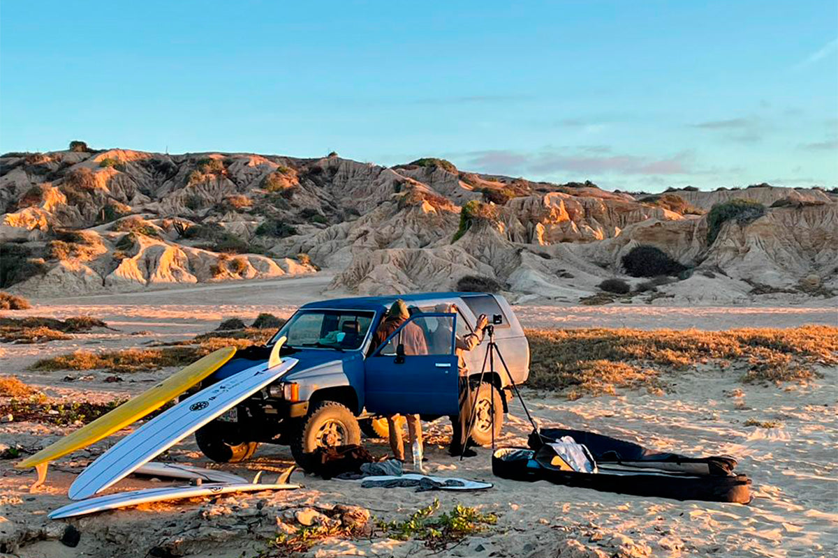 french surfers edouard delpero and damien castera with their truck and sourrounded by a quiver of surfboards on the edge of the desert in baja