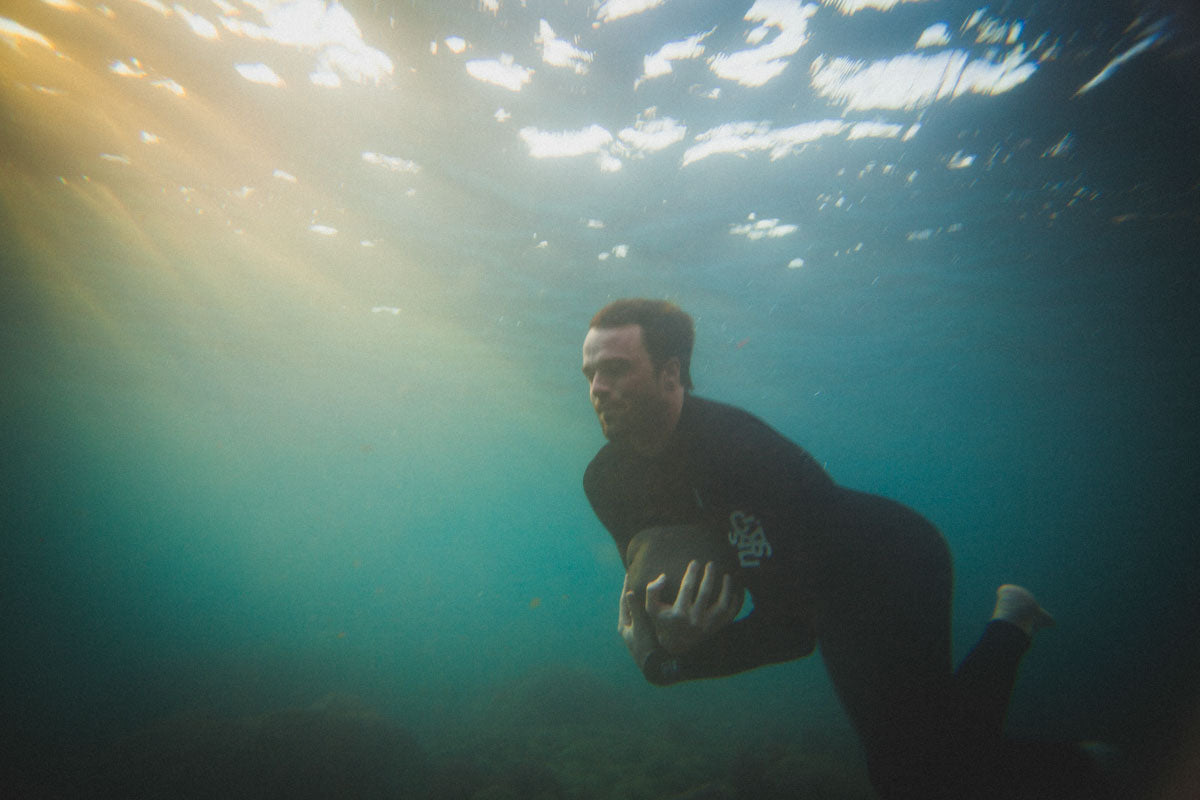 Joss Harris carries a boulder under water
