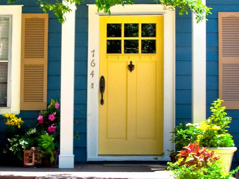Bright yellow front door and porch with flowers