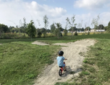 Kid on balance bike on dirt pump track in Ontario