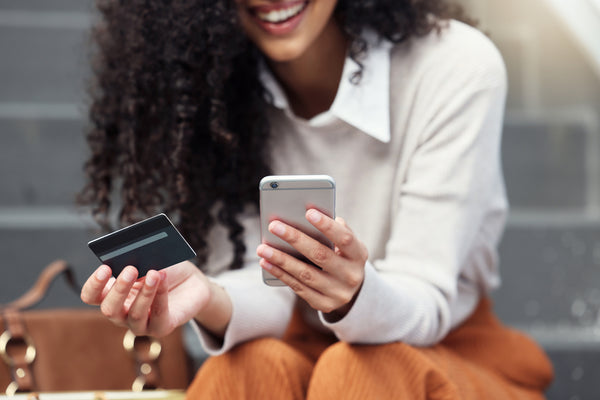 woman with phone and credit card