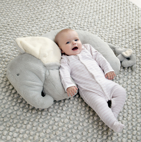 Baby laid on elephant cushion