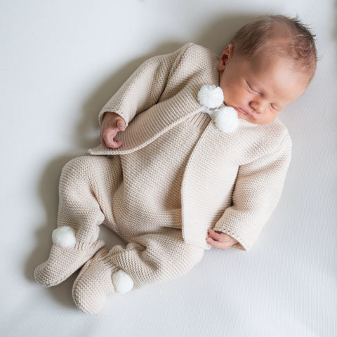Baby sleeping wearing cream knitwear