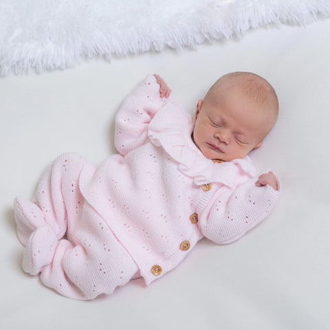 Baby sleeping wearing pink knitwear