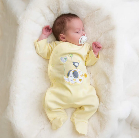 baby wearing lemon coloured sleepsuit