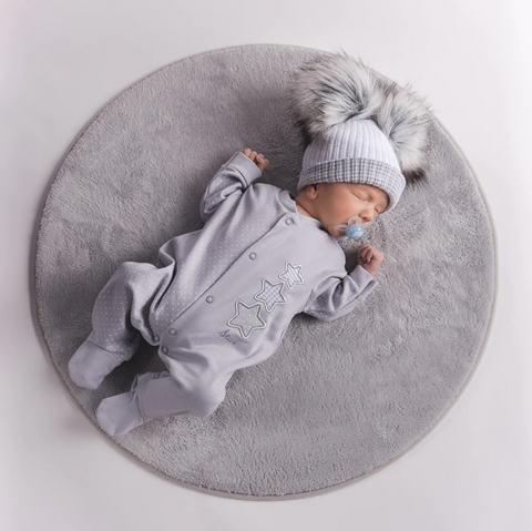 Baby wearing grey sleepsuit