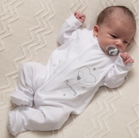 baby wearing white sleepsuit