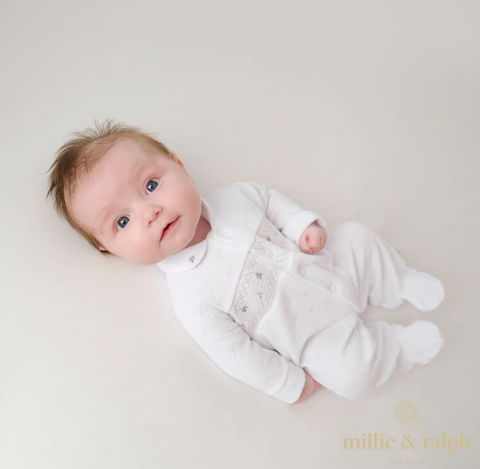 baby wearing white sleepsuit