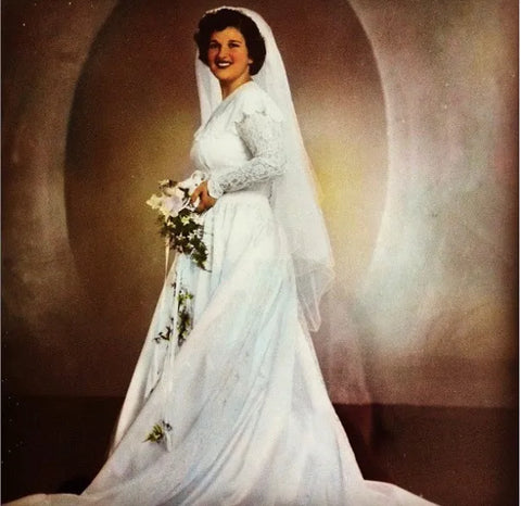 Woman from the 1940s in a white wedding dress holding a bouquet