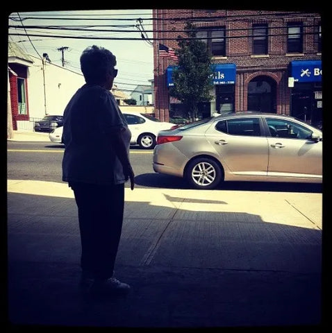 A woman stands on a city street sidewalk