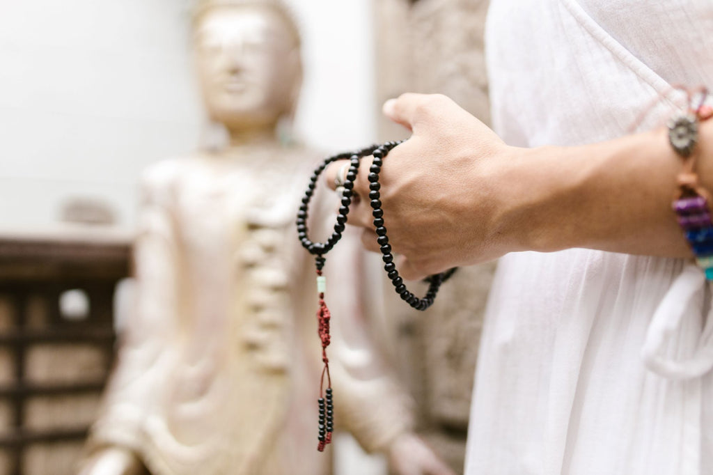 A woman wearing mala beads during meditation 