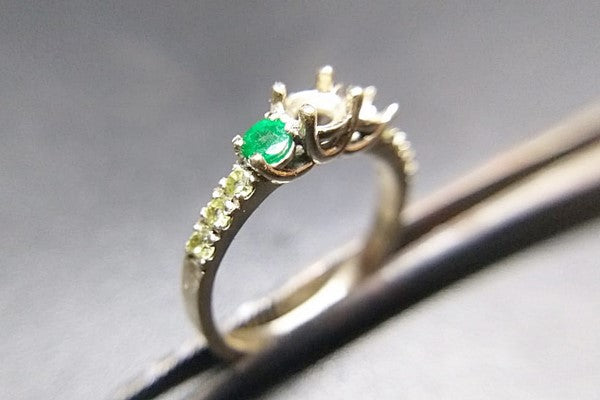 setting round emerald stones on unique engagement ring