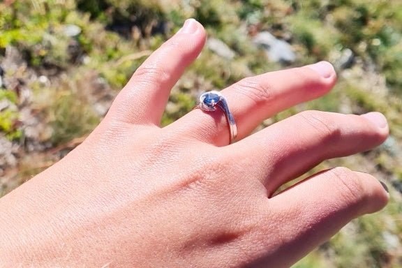 unique engagement ring design set with sapphire on finger
