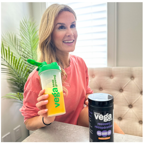 Nicole Osinga sitting at kitchen table with Vega Recover Sport Drink