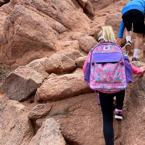 Girl rock climbing with Wanderwild The Explorer Kids Backpack in Mermaid Splash