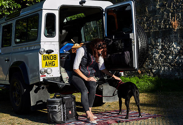 Women with Dog sat outside a landrover 