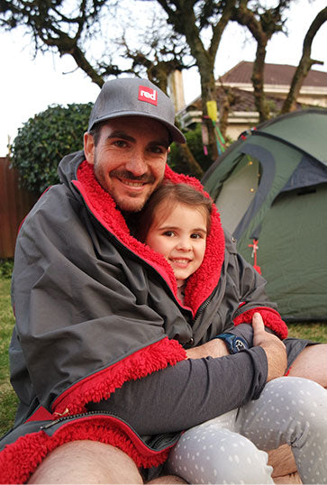 Travel Cup in front of a Little girl wearing the Red Original Pro Change Robe