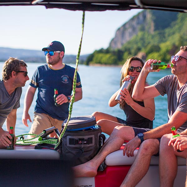 People Sitting around a waterproof cooler bag and enjoying a drink
