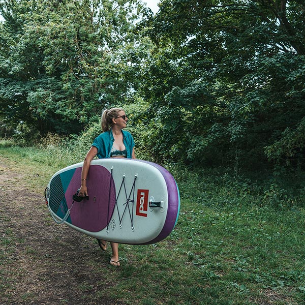 Woman carrying an inflatable paddle board