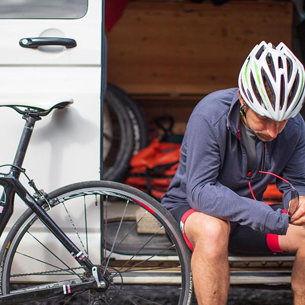 Cyclist sitting in a van taking a break