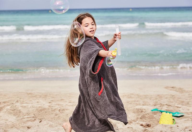 Girl In A Changing Robe Playing With Bubbles
