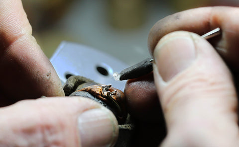 Sertissage d'un diamant sur une bague dans un atelier