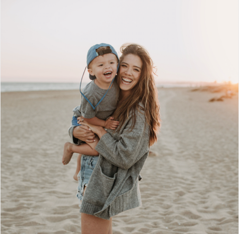 mom and kid smiling on the beach
