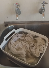 Foldable bucket with dirty nappies soaking in it.