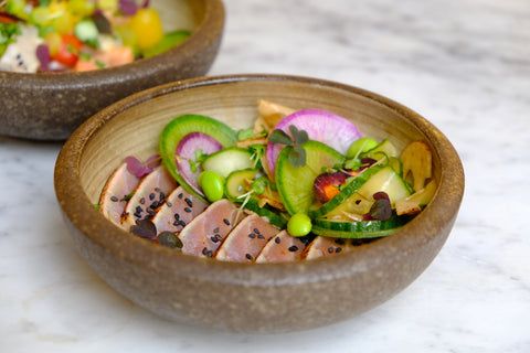 A bowl of food with fish and vegetables