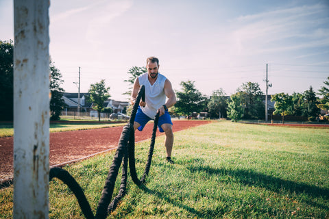 Man exercising with ropes outside