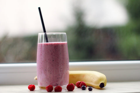 Healthy smoothie with fruits next to it