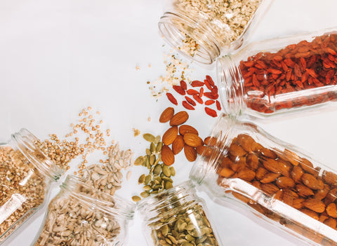 Collection of mixed nuts spilling out of jars