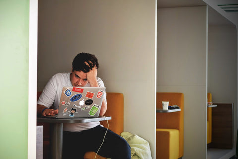 Man on laptop looking stressed