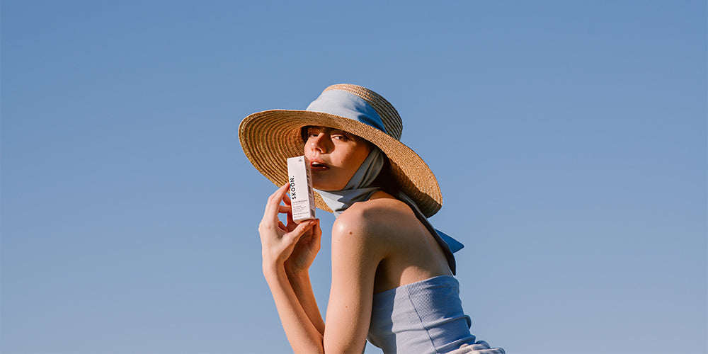 woman holding UV protective SKOON product