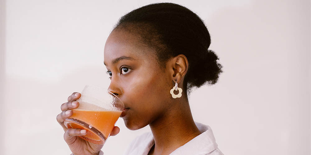 Woman drinking SKOON skincare product