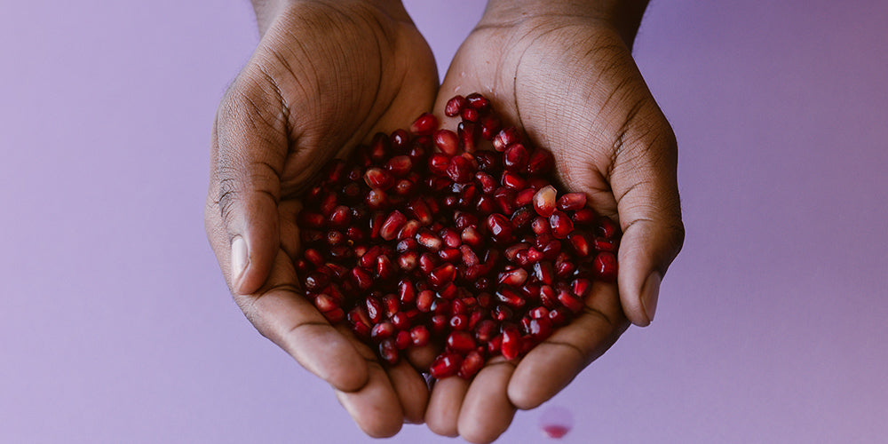 hands holding pomegranates