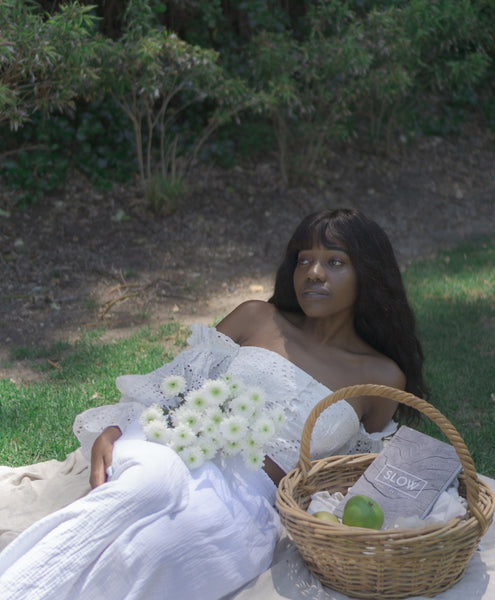 Ayune hair - Ethical hair extensions (Black woman laying in a garden)