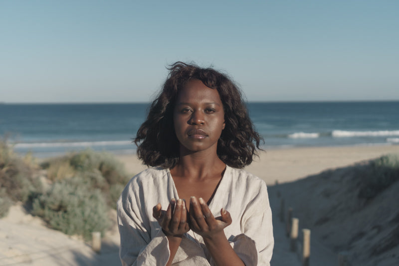 A Black woman looking at the camera with both palms facing upward