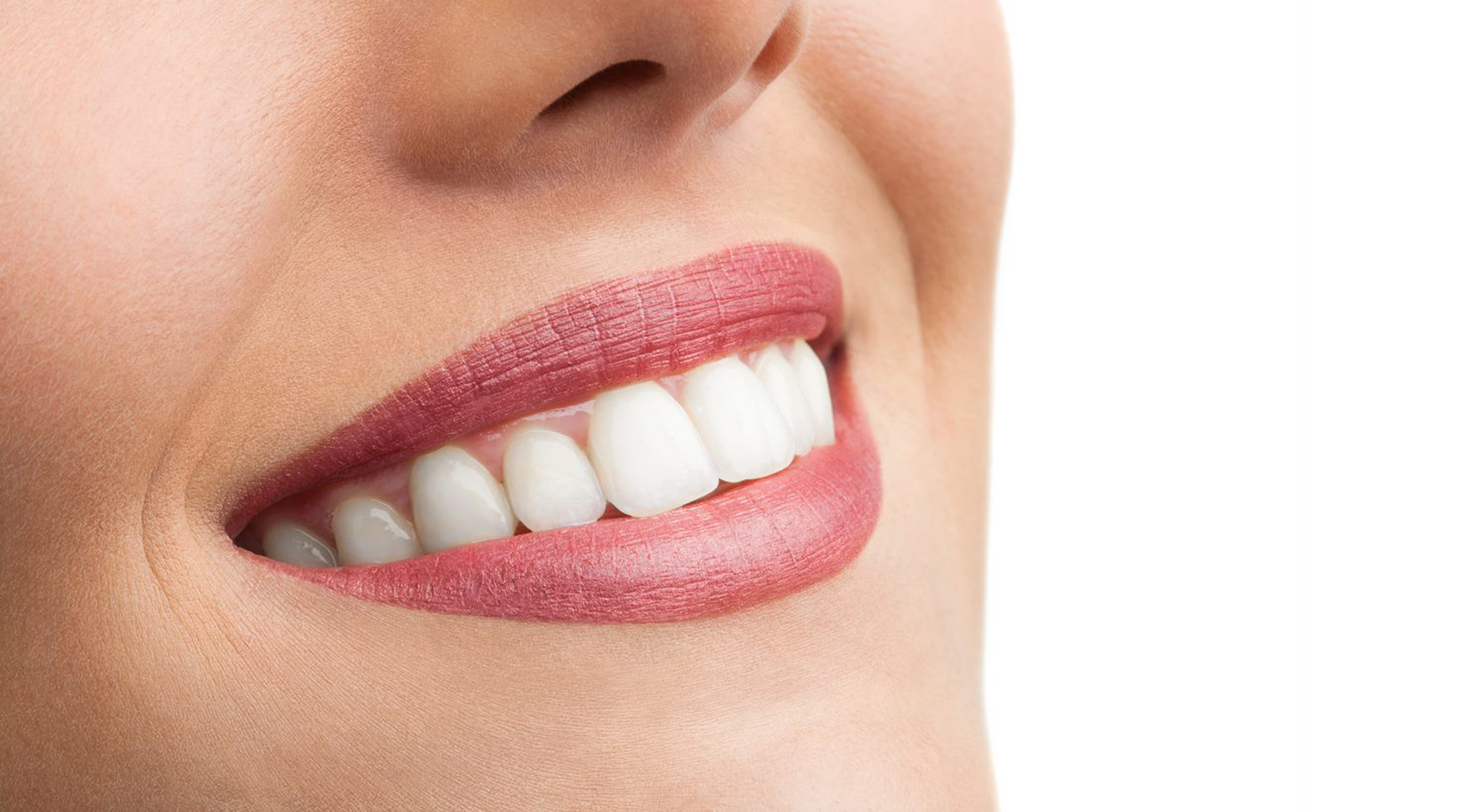 Image of a woman smiling, wearing pink lipstick