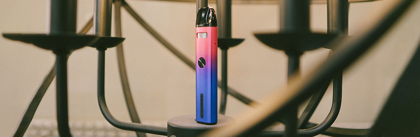 Upright UWell Caliburn G2 device in Gradient colour scheme resting on chandelier
