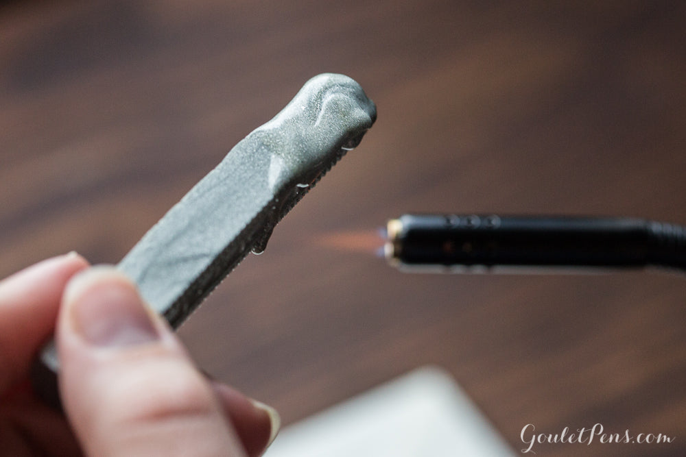 Using a torch to melt a stick of sealing wax