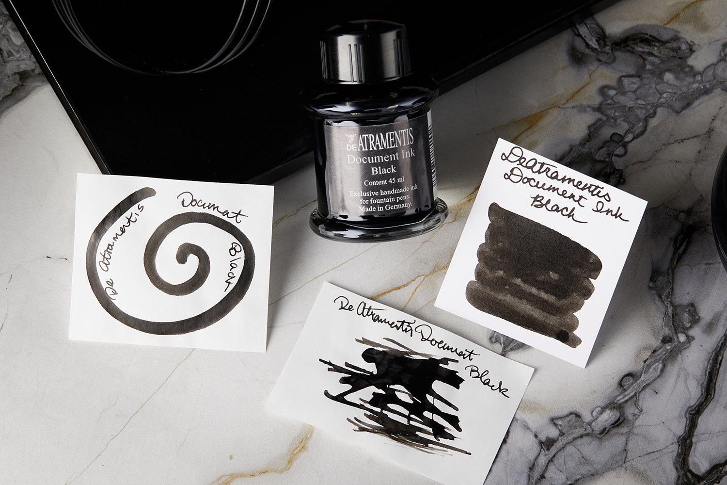 De Atramentis Document Black Ink bottle with arranged ink splatters