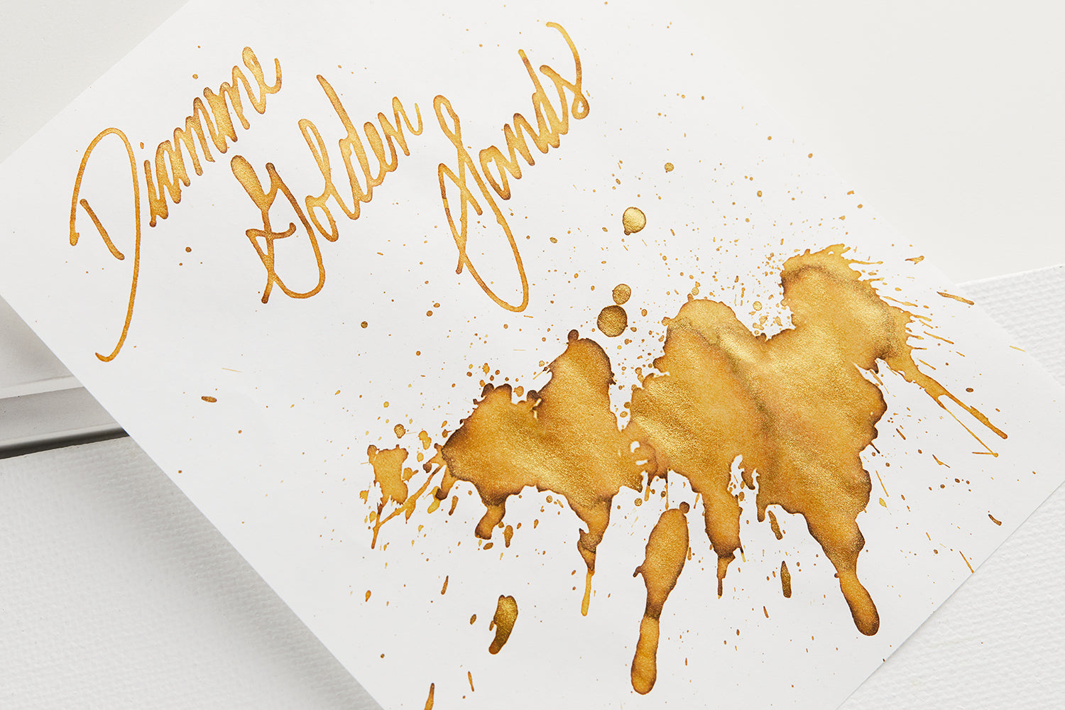 Diamine Golden Sands Fountain Pen Ink splatter and name on white paper