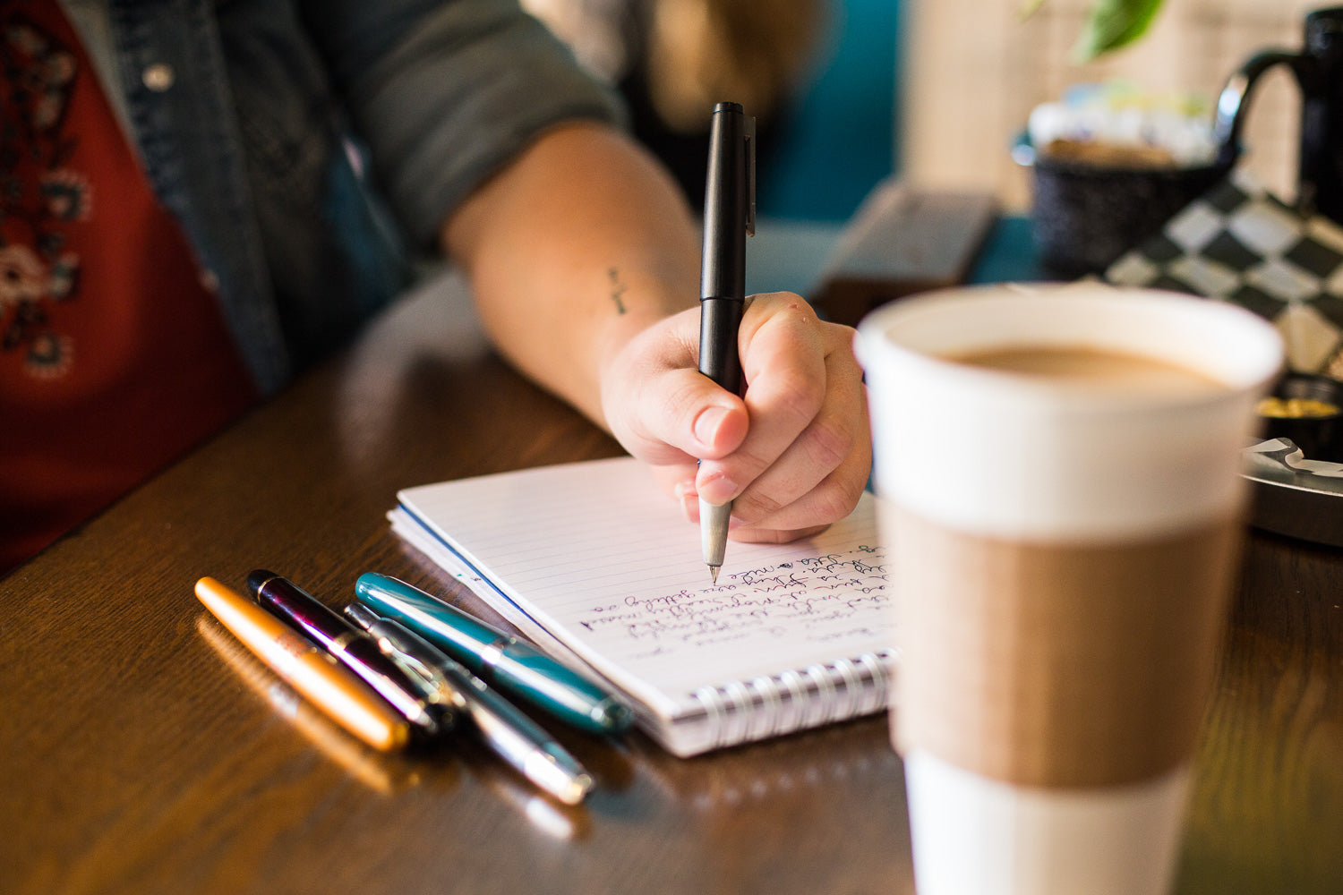 Left hand writing with a fountain pen in a coffee shop