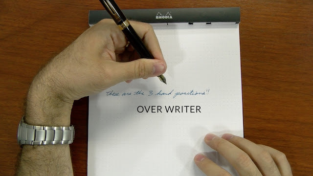 Left hand in the overwriter position over notebook paper
