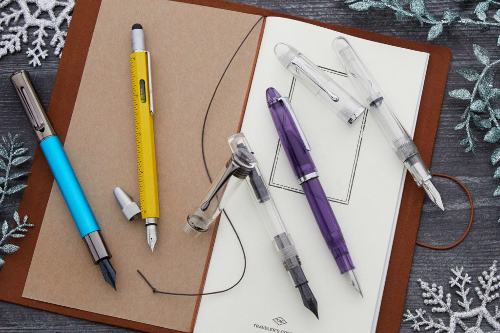 Assorted fountain pens on a Traveler's notebook